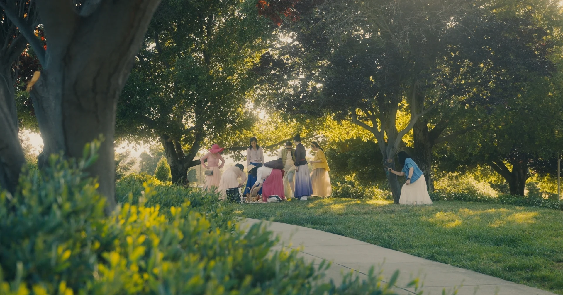 still shot from WHEN ARE YOU COMING HOME? a group of women picnic on the lush grass