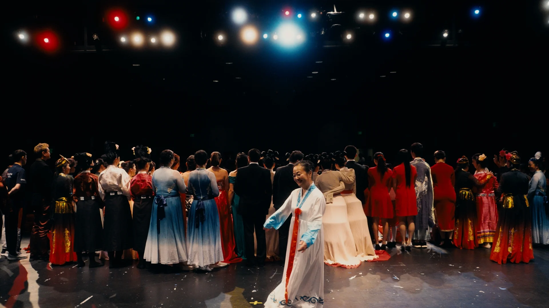 still shot from WHEN ARE YOU COMING HOME? a stage filled with dancers